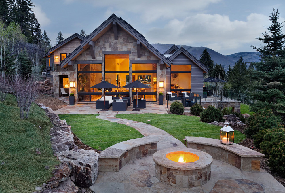 Unbedeckter Rustikaler Patio hinter dem Haus mit Feuerstelle und Natursteinplatten in Denver