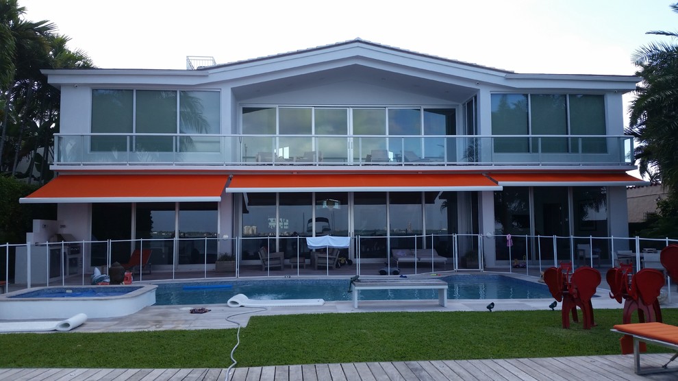 Foto di un grande patio o portico contemporaneo dietro casa con pavimentazioni in pietra naturale e un parasole