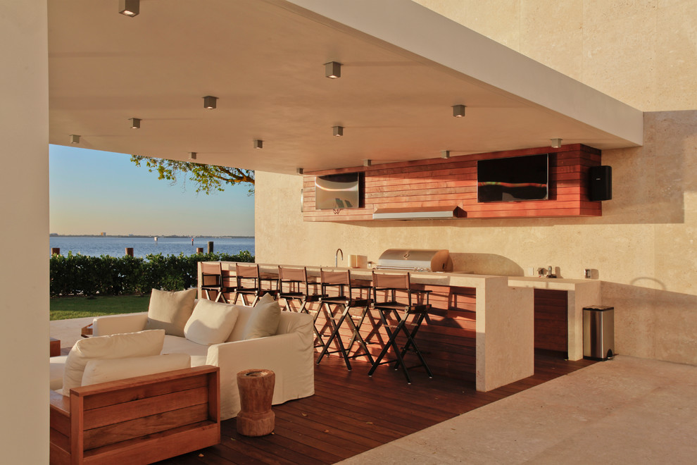 Aménagement d'une terrasse arrière moderne avec une cuisine d'été et une extension de toiture.