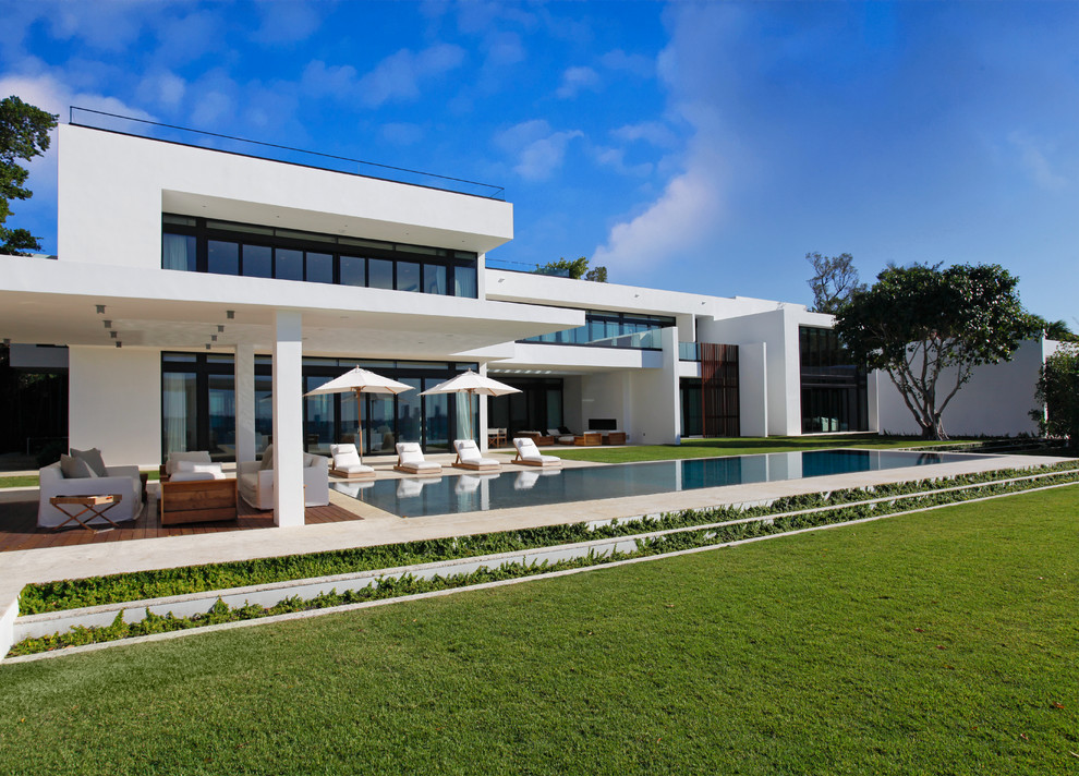 Cette image montre une grande terrasse arrière minimaliste avec une cuisine d'été, du carrelage et une extension de toiture.