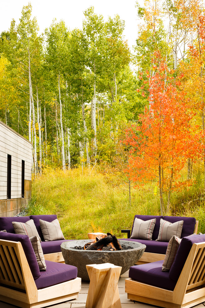 Patio - large contemporary backyard stone patio idea in Denver with a fire pit and no cover