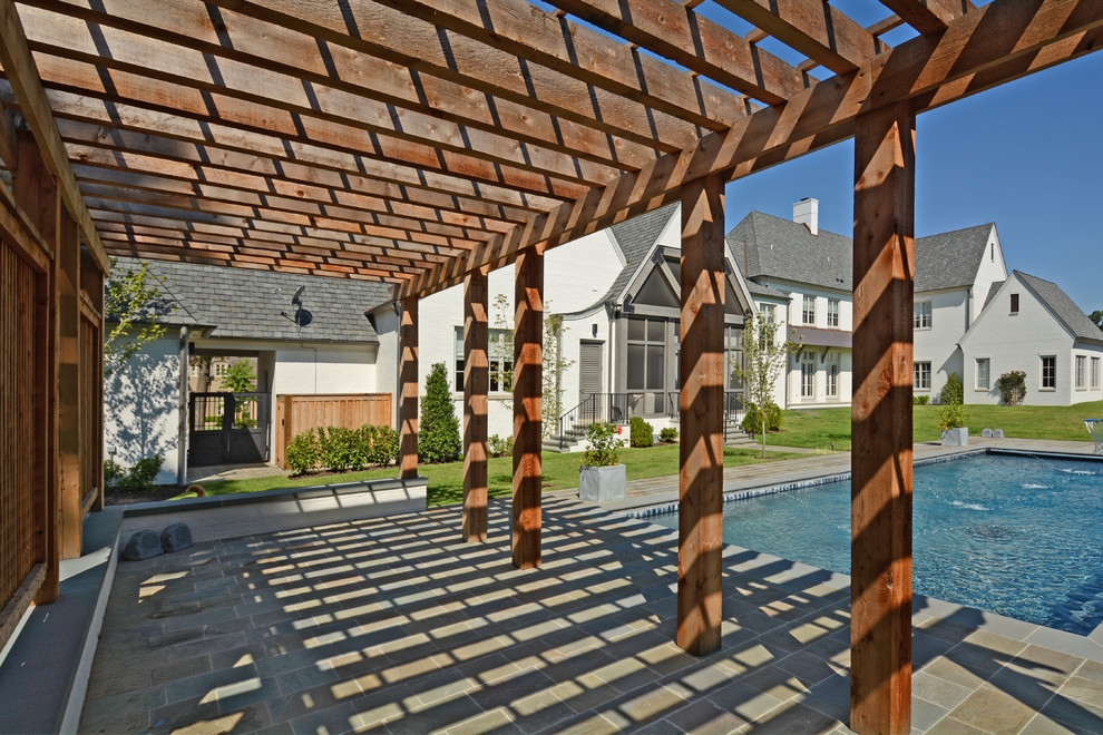Immagine di un grande patio o portico tradizionale dietro casa con fontane, pavimentazioni in pietra naturale e una pergola