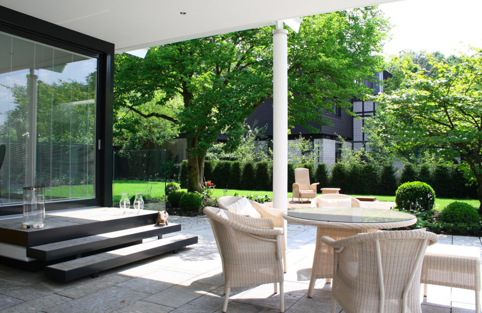 На фото: большой двор на боковом дворе в современном стиле с покрытием из каменной брусчатки, навесом и защитой от солнца