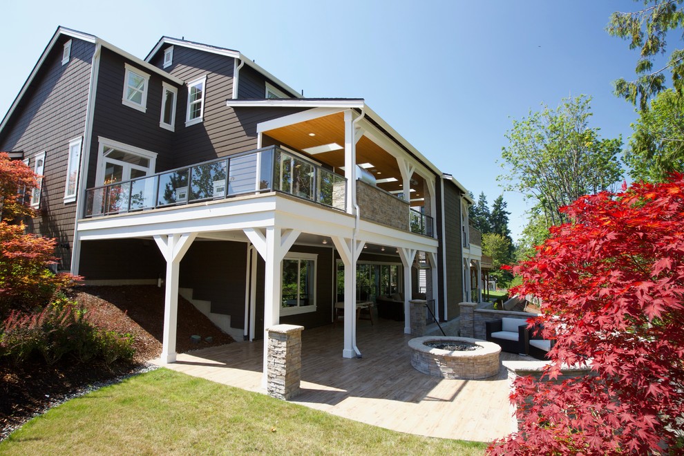 Modelo de patio minimalista grande en patio trasero y anexo de casas con chimenea y entablado
