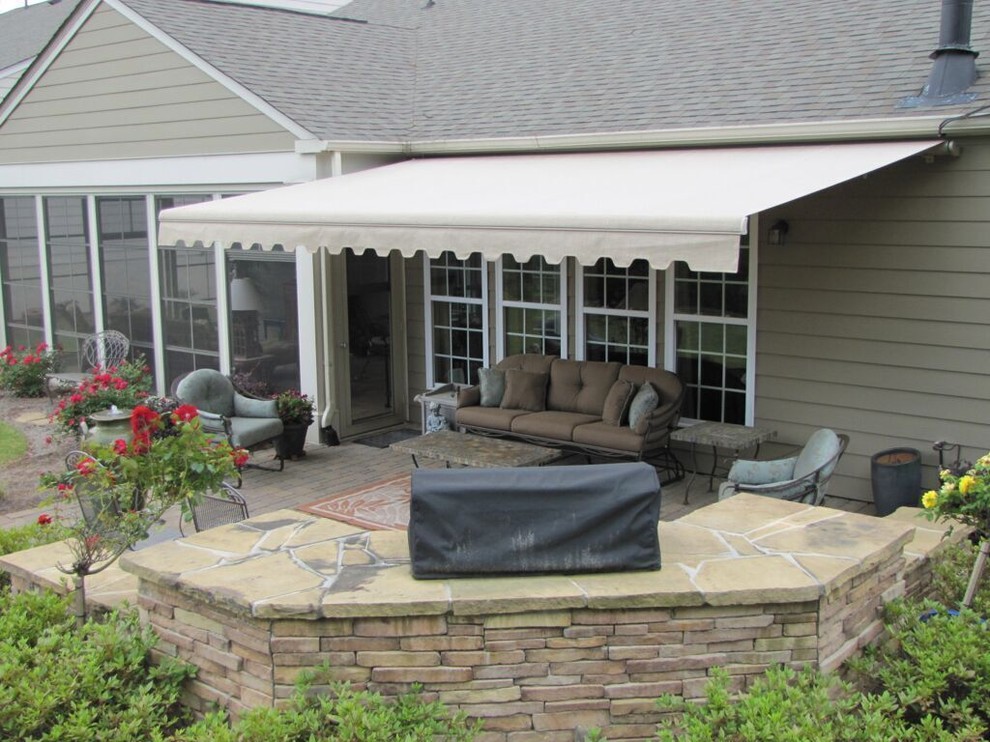 Design ideas for a medium sized classic back patio in Orange County with an outdoor kitchen, natural stone paving and an awning.