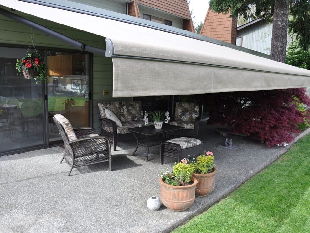 Inspiration for a large retro back patio in Orange County with concrete slabs and an awning.