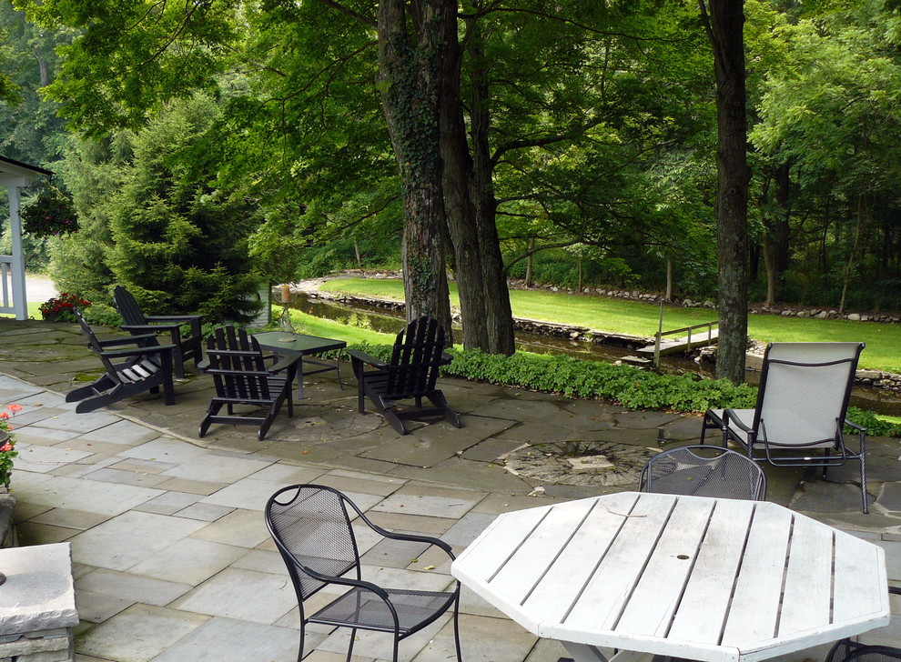 Foto di un patio o portico country di medie dimensioni e dietro casa con pavimentazioni in pietra naturale