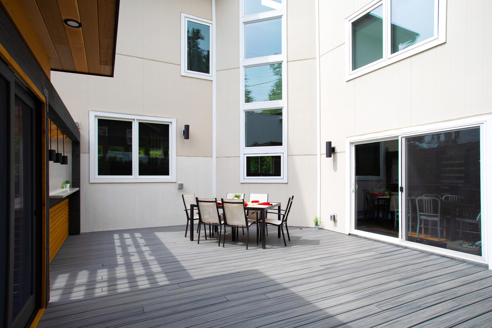 На фото: большая пергола во дворе частного дома на заднем дворе в стиле модернизм с летней кухней и настилом