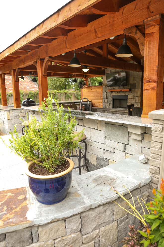 Inspiration for a large traditional back patio in Other with an outdoor kitchen, concrete slabs and a pergola.