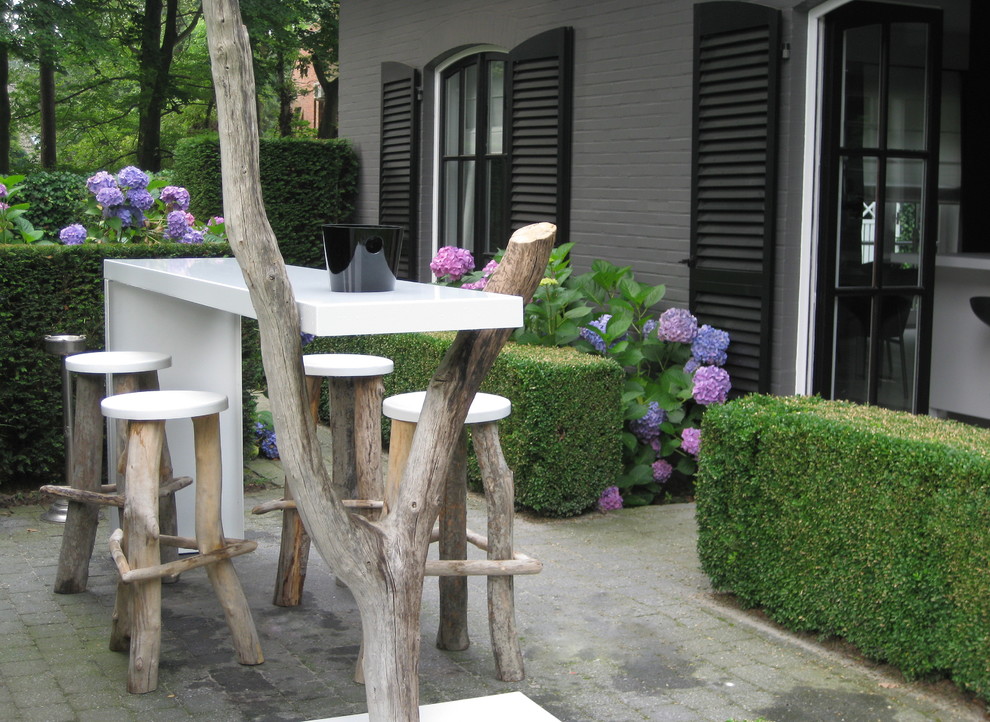 Imagen de patio contemporáneo con adoquines de ladrillo