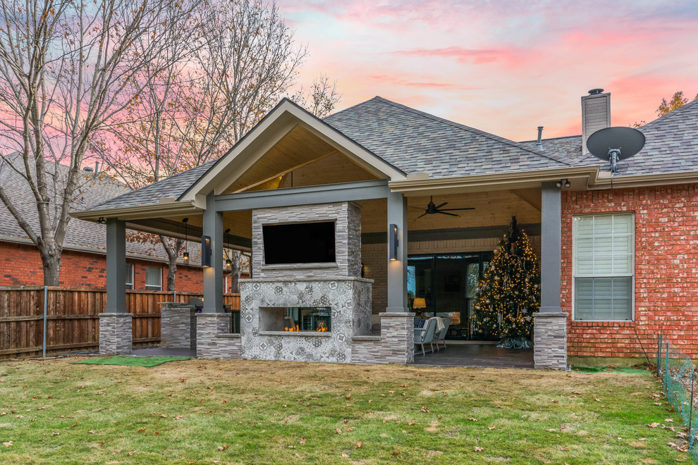 Foto di un patio o portico minimalista di medie dimensioni e dietro casa con un focolare, piastrelle e un tetto a sbalzo