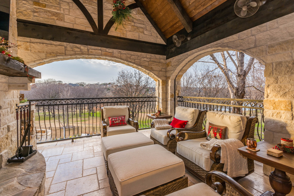 Large mountain style backyard tile patio photo in Houston with a fireplace and a roof extension