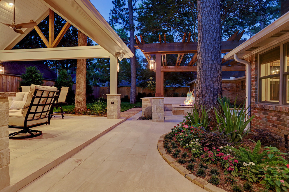 Réalisation d'une grande terrasse arrière design avec une cuisine d'été, du carrelage et une extension de toiture.