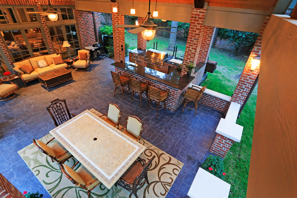 Cette photo montre une terrasse arrière craftsman avec une cuisine d'été, du béton estampé et une extension de toiture.