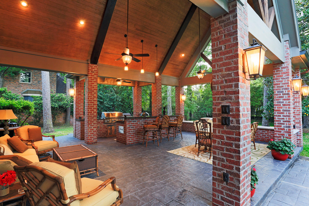 Esempio di un grande patio o portico stile americano dietro casa con cemento stampato e un tetto a sbalzo