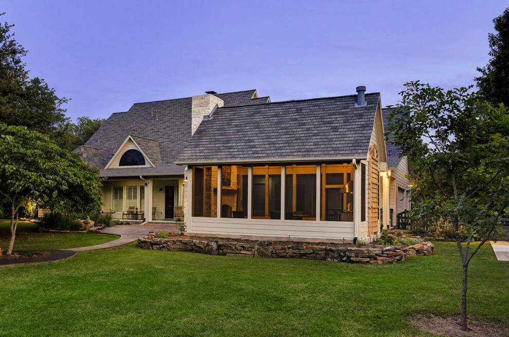 Cette image montre une terrasse arrière traditionnelle de taille moyenne avec une cuisine d'été, des pavés en pierre naturelle et une extension de toiture.