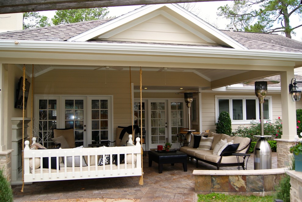 Aménagement d'une terrasse arrière campagne de taille moyenne avec un foyer extérieur, du béton estampé et une extension de toiture.