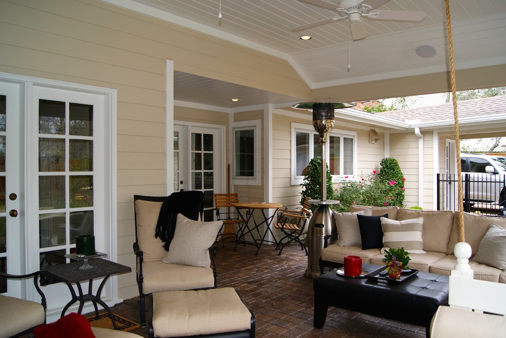 Idée de décoration pour une terrasse arrière champêtre de taille moyenne avec un foyer extérieur, des pavés en brique et une extension de toiture.