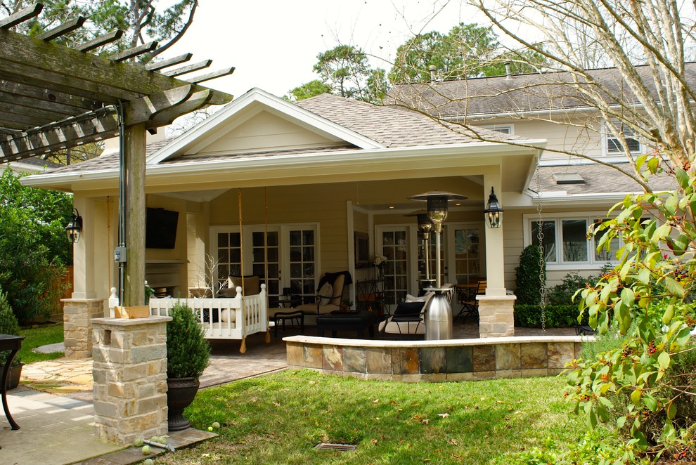 Esempio di un patio o portico country di medie dimensioni e dietro casa con un focolare, pavimentazioni in mattoni e un tetto a sbalzo