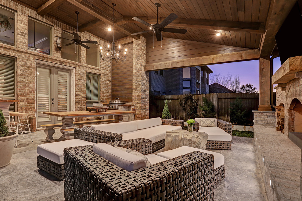 Patio - mid-sized rustic backyard concrete patio idea in Houston with a fireplace and a roof extension