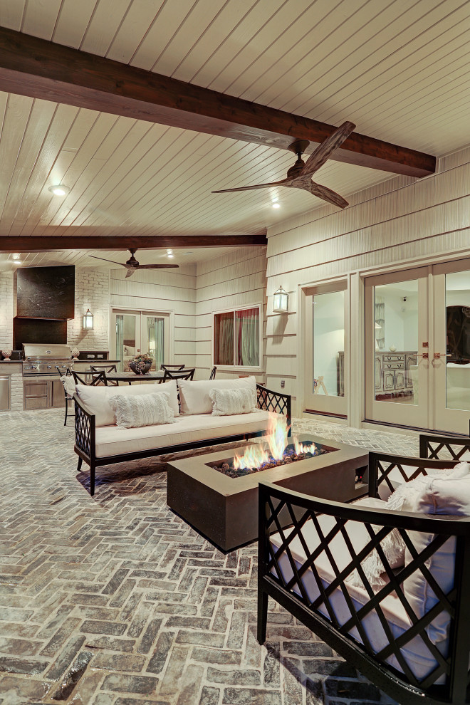 Aménagement d'une terrasse arrière classique de taille moyenne avec une cuisine d'été, des pavés en brique et une extension de toiture.