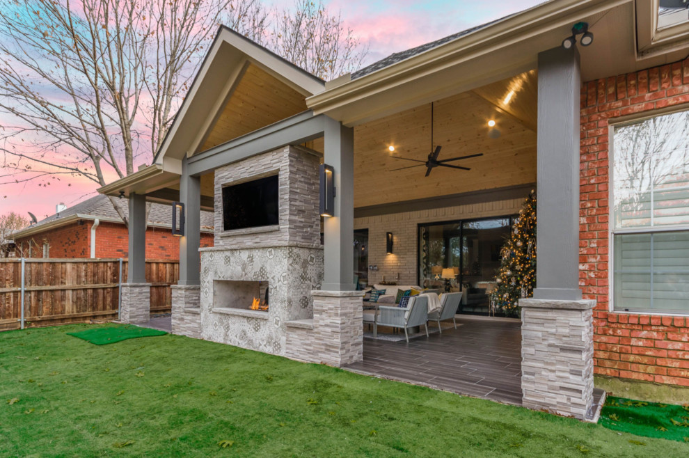 Esempio di un patio o portico minimal di medie dimensioni e dietro casa con un caminetto, piastrelle e un tetto a sbalzo
