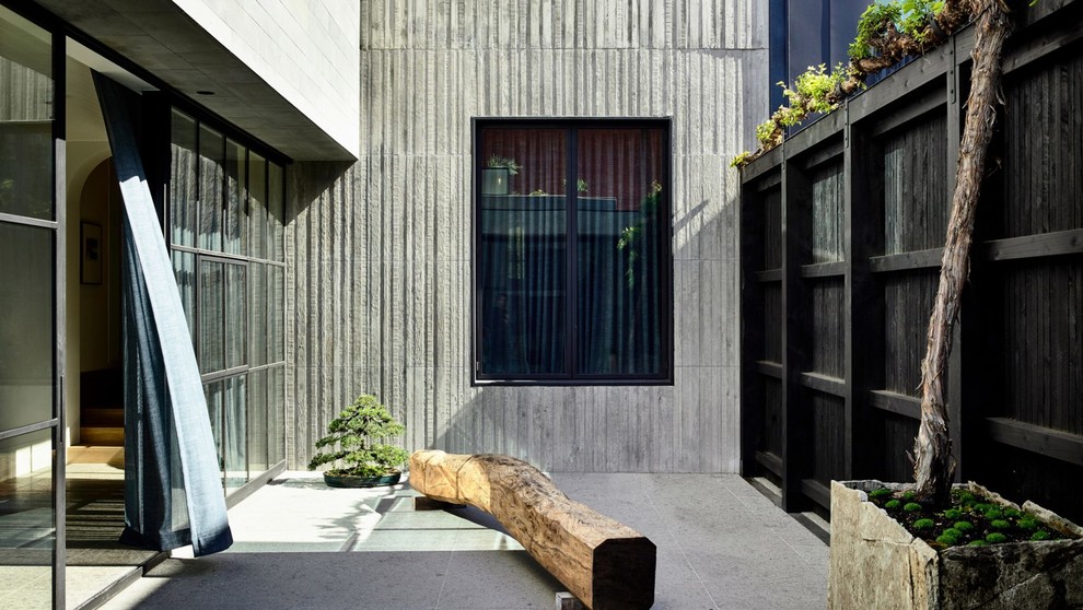 Ispirazione per un patio o portico minimalista in cortile con piastrelle e nessuna copertura