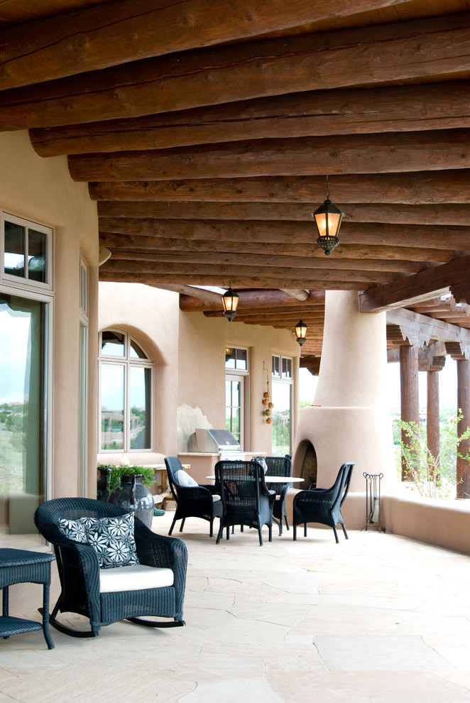 Foto di un patio o portico american style con pavimentazioni in pietra naturale e un tetto a sbalzo