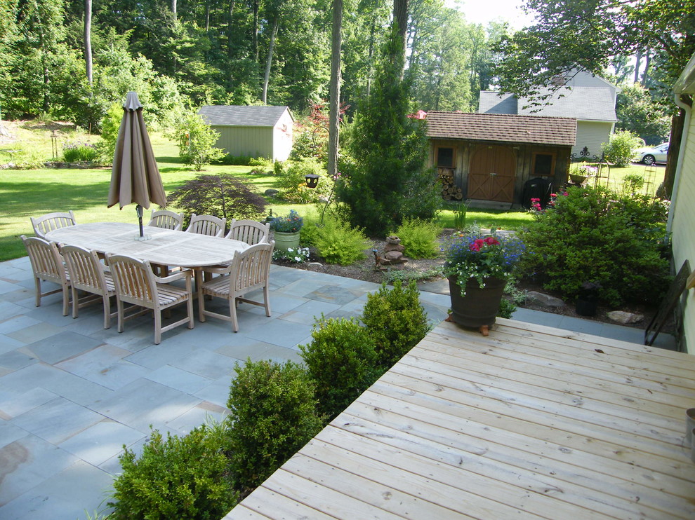 Immagine di un grande patio o portico chic dietro casa con pavimentazioni in pietra naturale e nessuna copertura