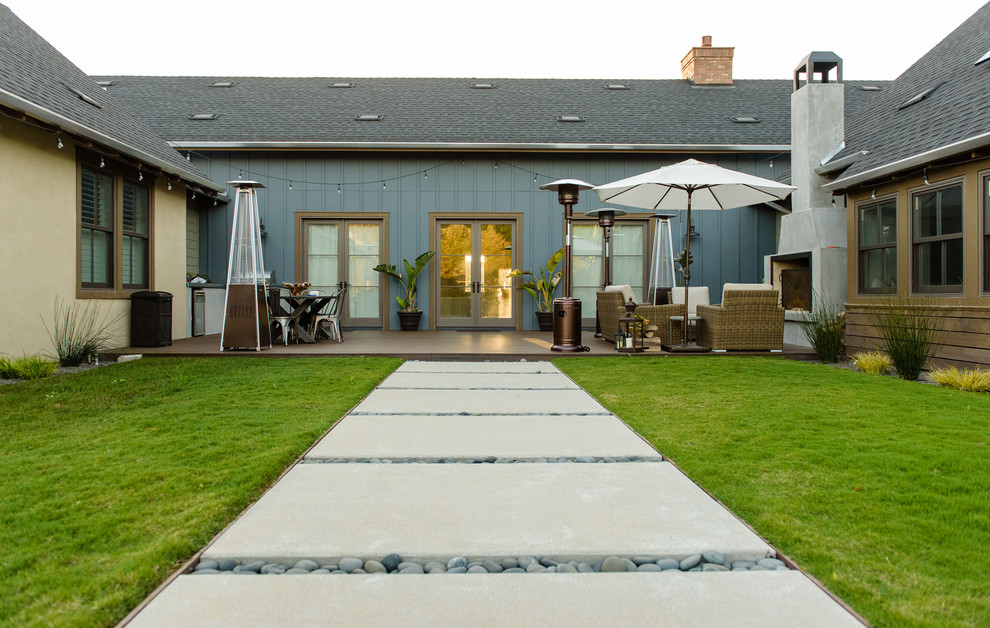 Imagen de patio clásico de tamaño medio en patio trasero con brasero, entablado y toldo