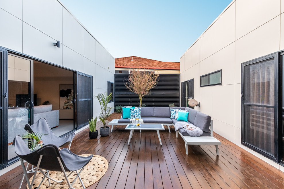 This is an example of a modern courtyard patio in Other with decking and no cover.