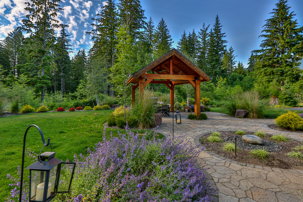 Imagen de patio de estilo americano grande en patio trasero con fuente, adoquines de piedra natural y cenador