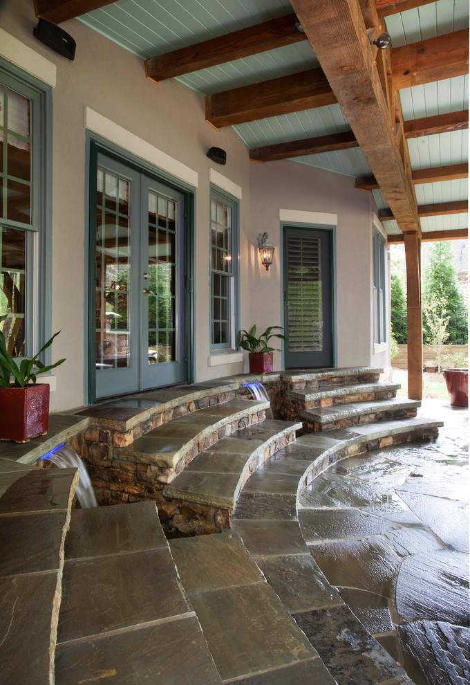 Inspiration pour une grande terrasse arrière traditionnelle avec une cuisine d'été, des pavés en pierre naturelle et une extension de toiture.
