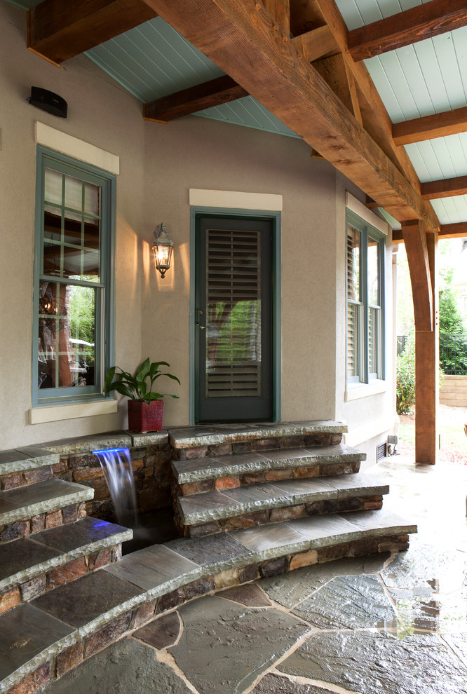 Ispirazione per un grande patio o portico classico dietro casa con pavimentazioni in pietra naturale e un tetto a sbalzo