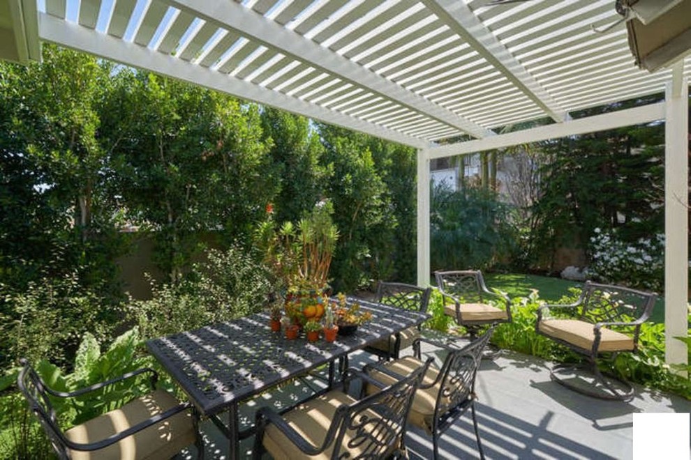 Ispirazione per un patio o portico mediterraneo di medie dimensioni e nel cortile laterale con un giardino in vaso, pavimentazioni in cemento e una pergola