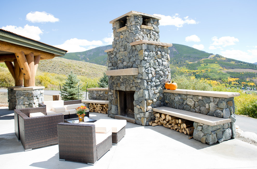 Foto di un patio o portico rustico con un focolare e lastre di cemento