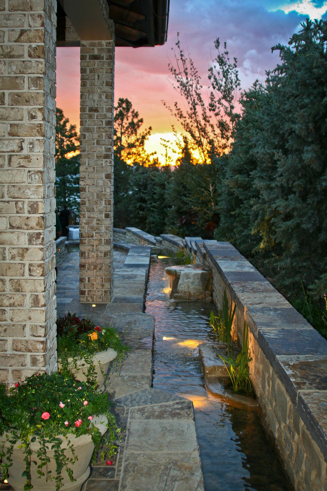 Inspiration for a mid-sized mediterranean backyard tile patio fountain remodel in Denver with a gazebo