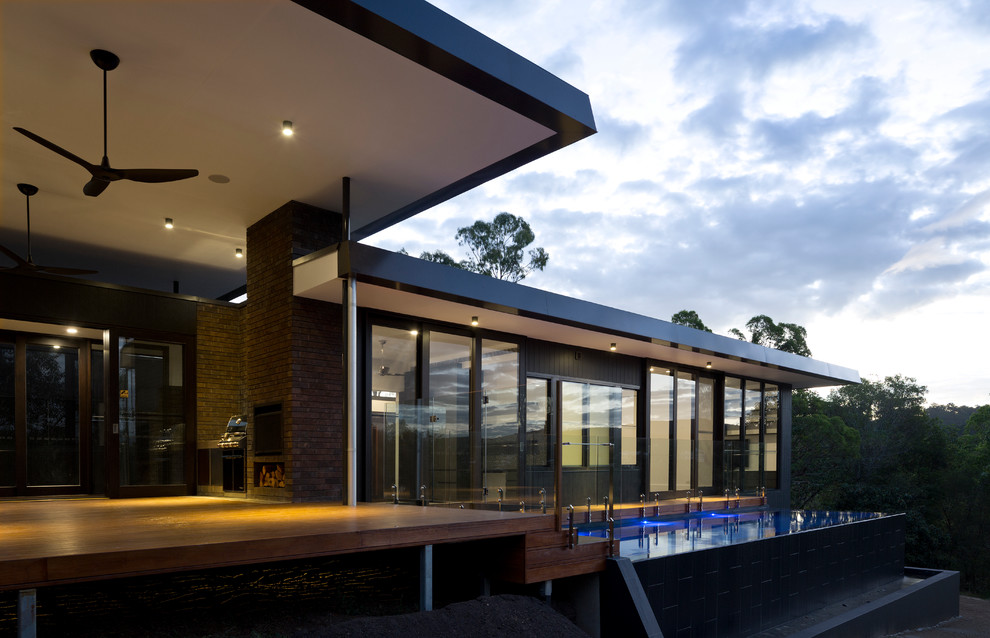 Großer, Überdachter Moderner Patio neben dem Haus mit Feuerstelle und Dielen in Brisbane