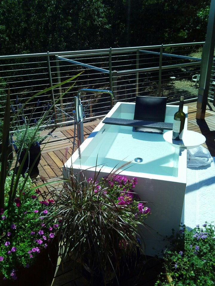 Cette photo montre une terrasse en bois arrière moderne de taille moyenne avec un point d'eau et aucune couverture.