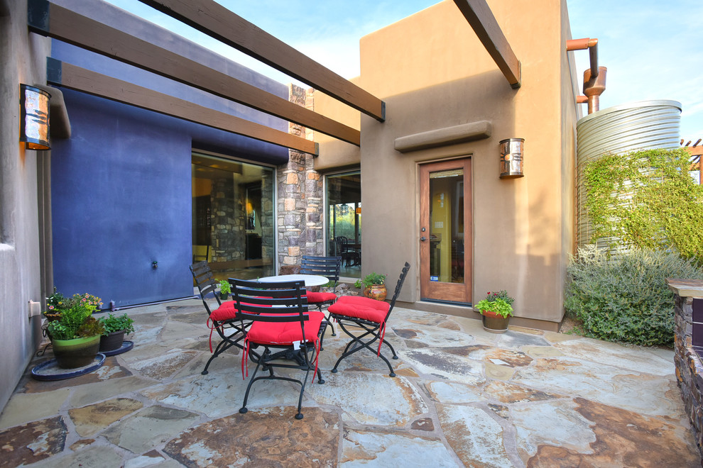 Immagine di un grande patio o portico american style dietro casa con un focolare, pavimentazioni in pietra naturale e una pergola