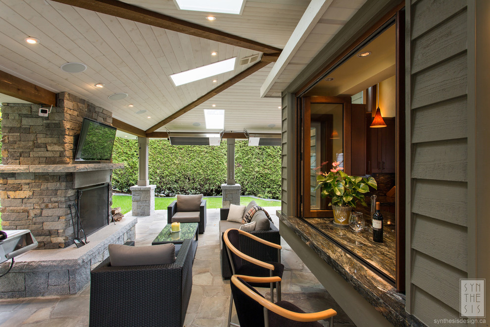 Medium sized contemporary back patio in Vancouver with a fire feature, natural stone paving and a roof extension.