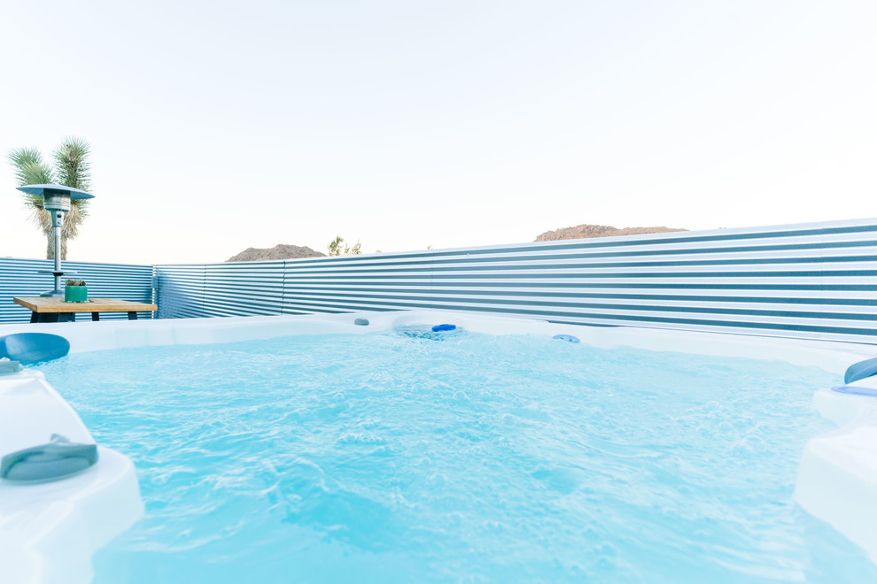 Diseño de piscina ecléctica grande en patio trasero con losas de hormigón