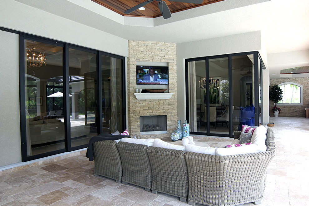 Large modern back patio in Miami with a roof extension, a fire feature and tiled flooring.