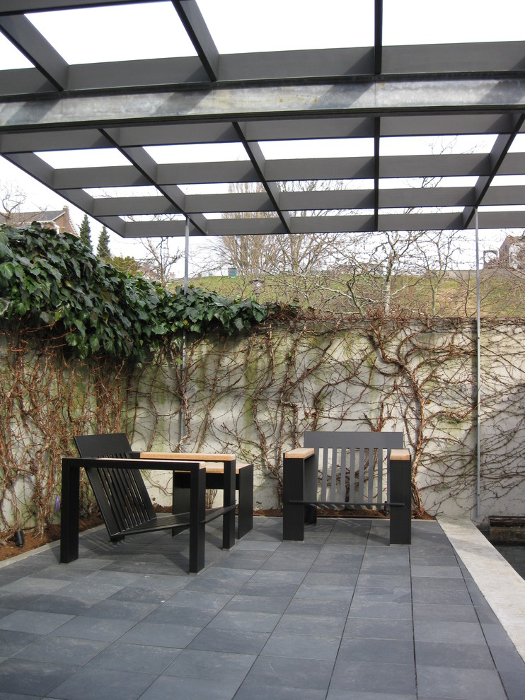 Immagine di un patio o portico minimalista con una pergola