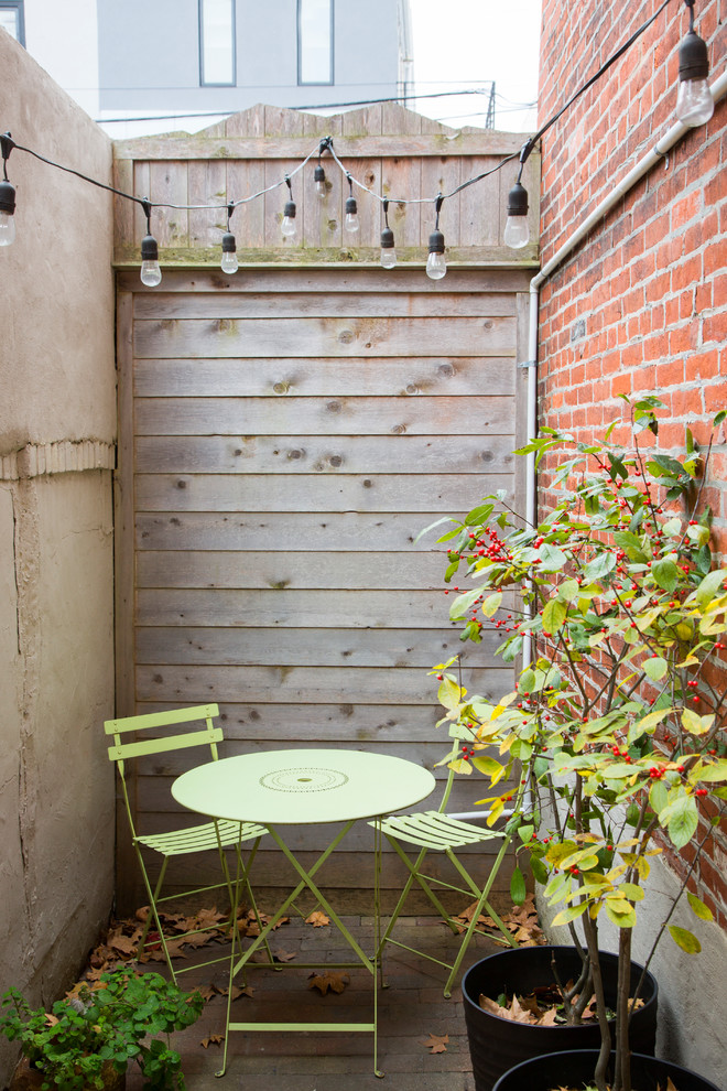 Ispirazione per un piccolo patio o portico eclettico nel cortile laterale con pavimentazioni in cemento