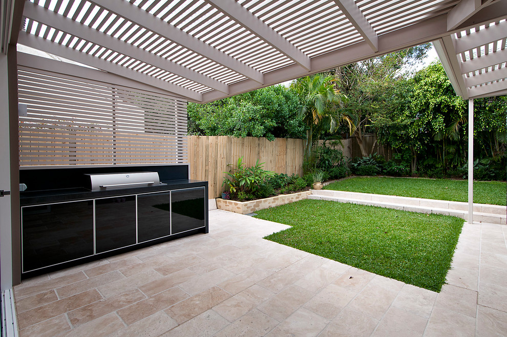 Foto di un patio o portico minimal di medie dimensioni e dietro casa con pavimentazioni in pietra naturale e un parasole