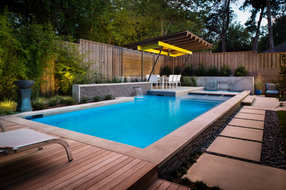 Idées déco pour une piscine arrière moderne de taille moyenne avec une terrasse en bois.