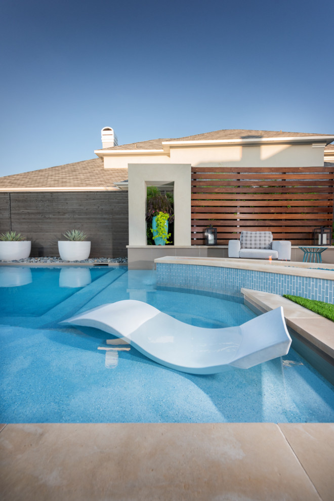 На фото: бассейн среднего размера на заднем дворе в стиле модернизм с настилом