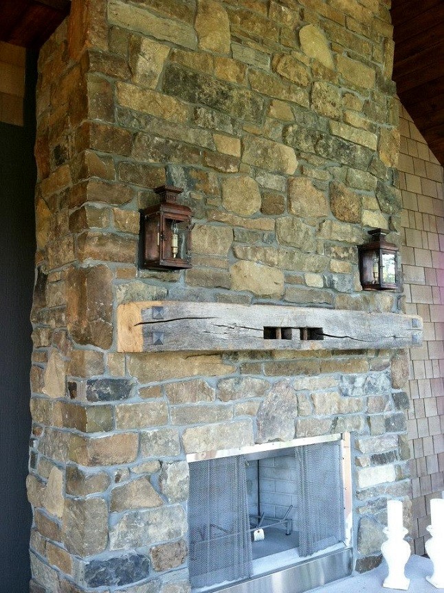 This is an example of a rustic back patio in Other with a fireplace and a roof extension.