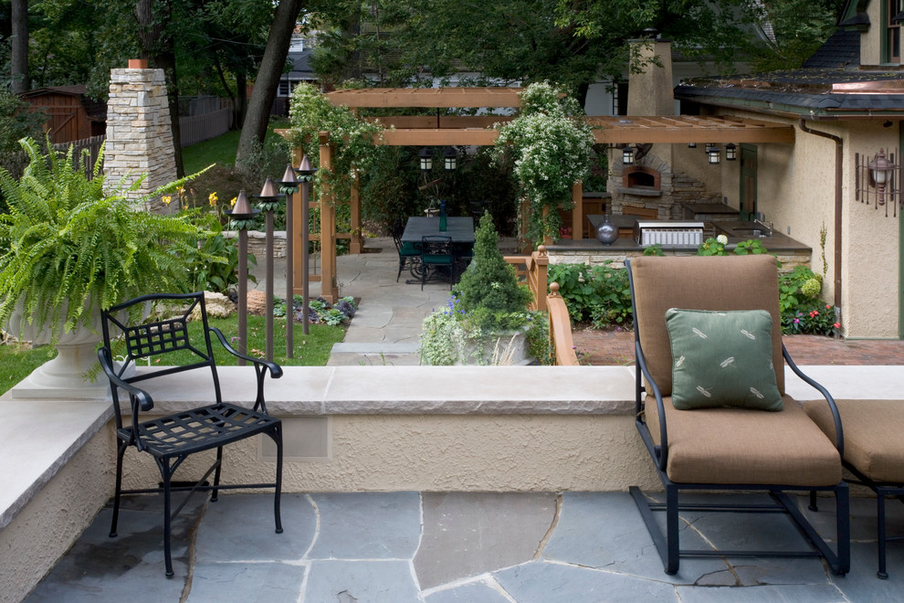 Modelo de patio bohemio de tamaño medio en patio trasero con cocina exterior, adoquines de piedra natural y pérgola